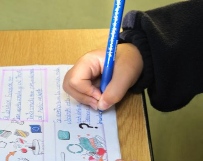 Alumno escribiendo en clase - Prematriculación 2026-2027